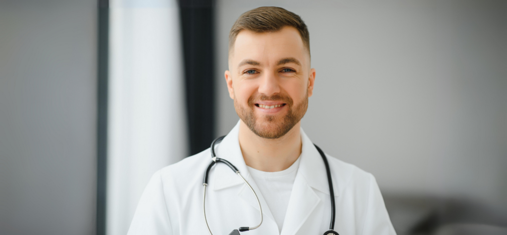 Médecin homme, en sarrau blanc, souriant